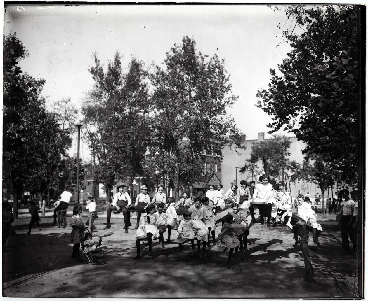 Photographie horizontale en noir et blanc montrant des enfants jouant sur des balançoires dans un parc non identifié - Unknown