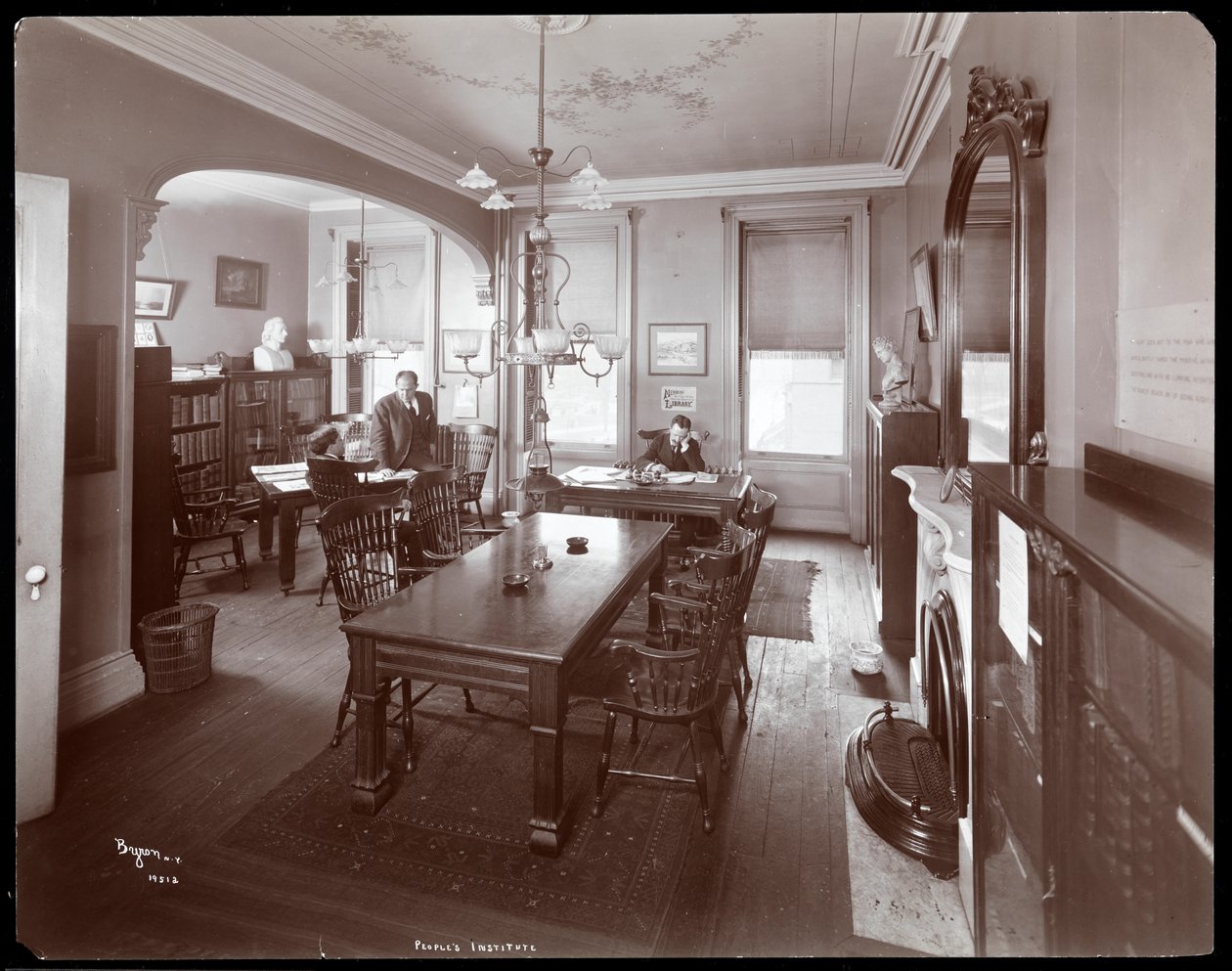 Vue intérieure de trois hommes dans la bibliothèque de l