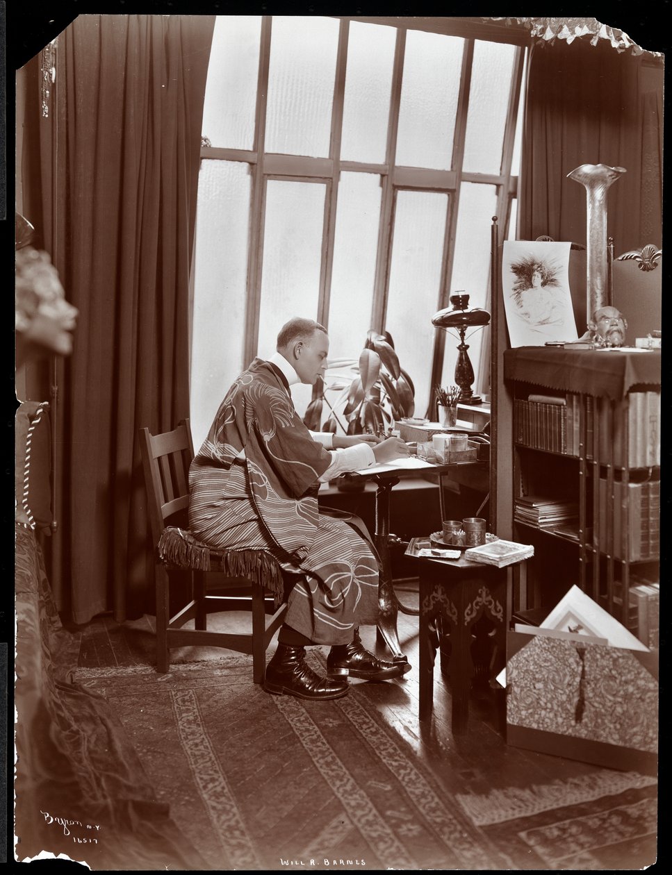 Will R. Barnes en robe, assis à son bureau dans son studio, 1903 (tirage gélatino-argentique) - Byron Company