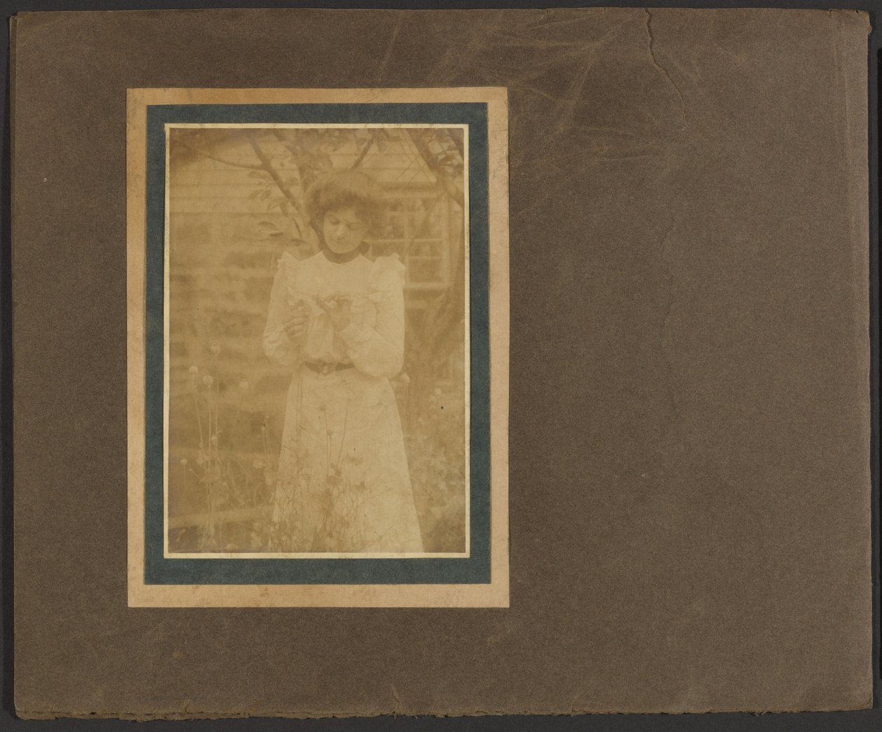 [Femme tenant une fleur dans un jardin] - Louis Fleckenstein