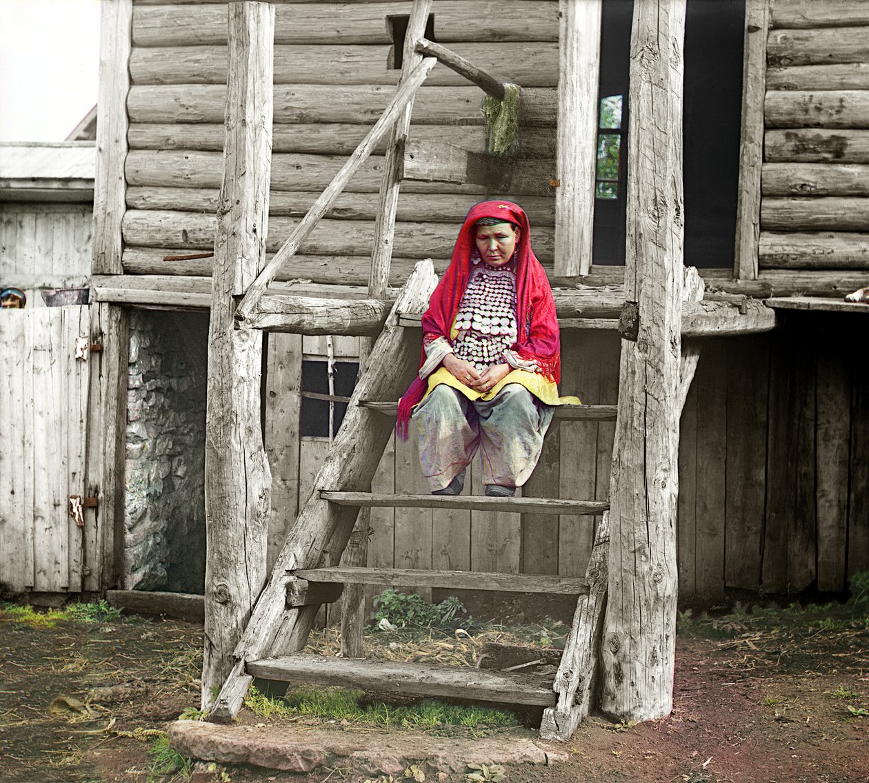 Femme bachkire en costume folklorique assise sur les escaliers de sa maison en bois, Monts Oural, Empire russe, 1910 - Sergey Prokudin Gorsky