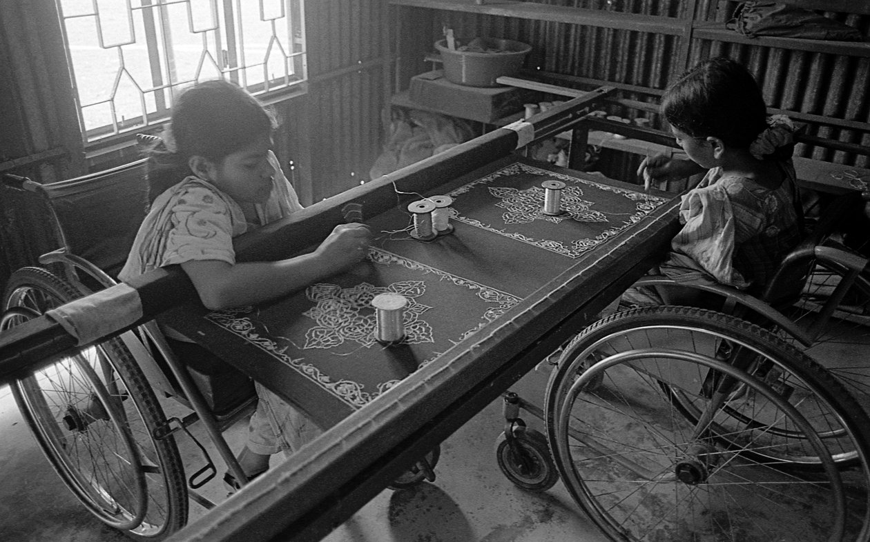 Deux filles handicapées font de la broderie sur des vêtements au Centre de Réhabilitation des Paralysés, CRP à Savar, Dhaka, Bangladesh. 2005. - Unbekannt Unbekannt