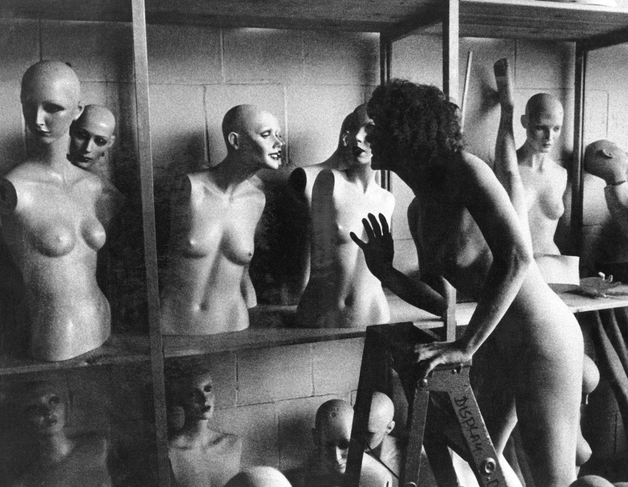 États-Unis : vers 1966 Une femme nue sur une échelle discute avec une tête de mannequin. - Unbekannt Unbekannt